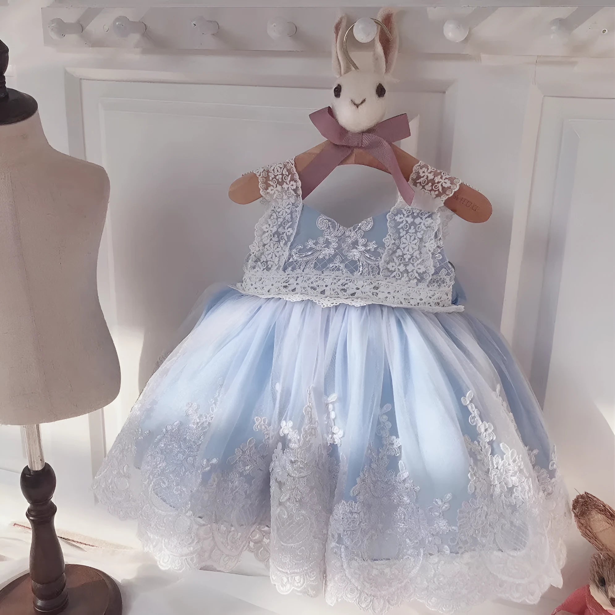 Ocean Blue baby girl princess dress with lace detailing on a hanger