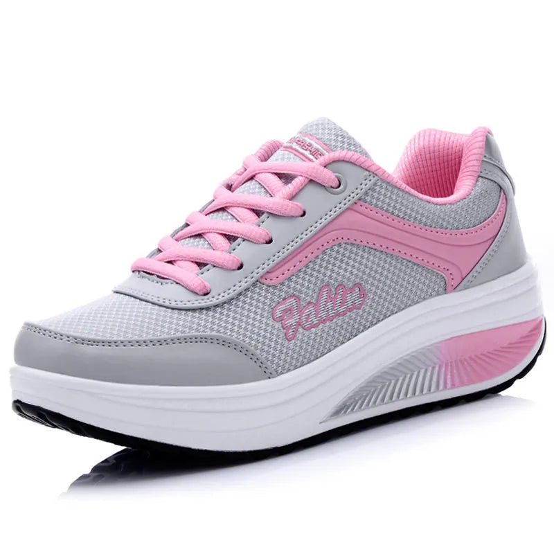 Women's grey powder heelless sports shoes with a middle heel on a plain background