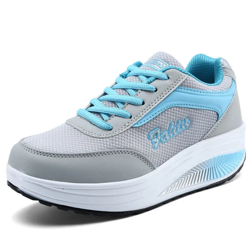 Women's grey powder heelless sports shoes with a middle heel on a plain background