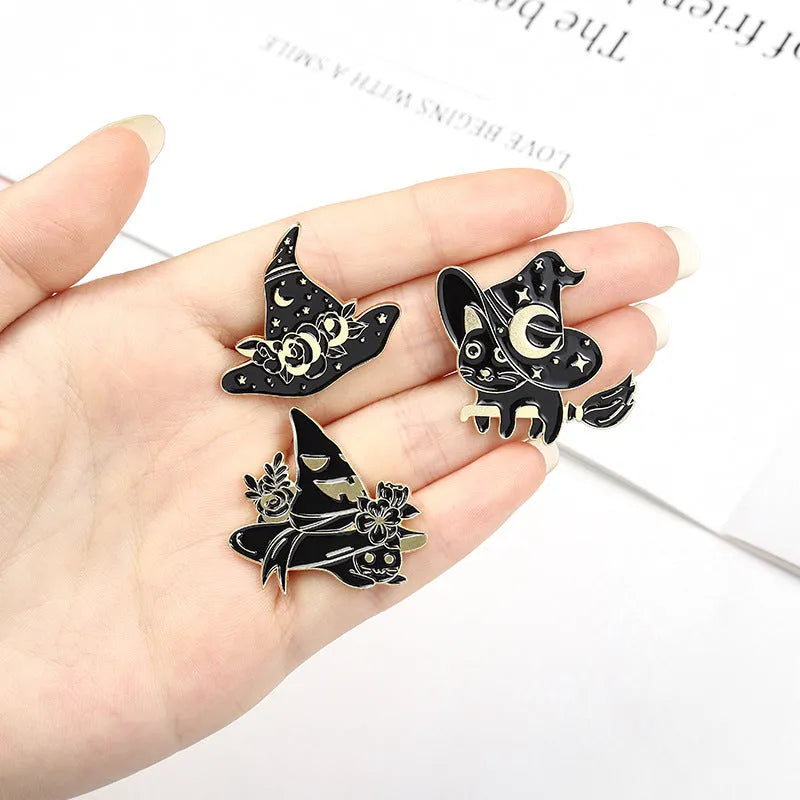 Punk black magic cat brooch with wizard hat design in alloy with baking varnish finish on white background.