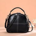 Simple round leather handbag with a soft handle and zipper, shown in wine red colour.