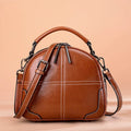 Round leather handbag with zip and soft handles in wine red colour