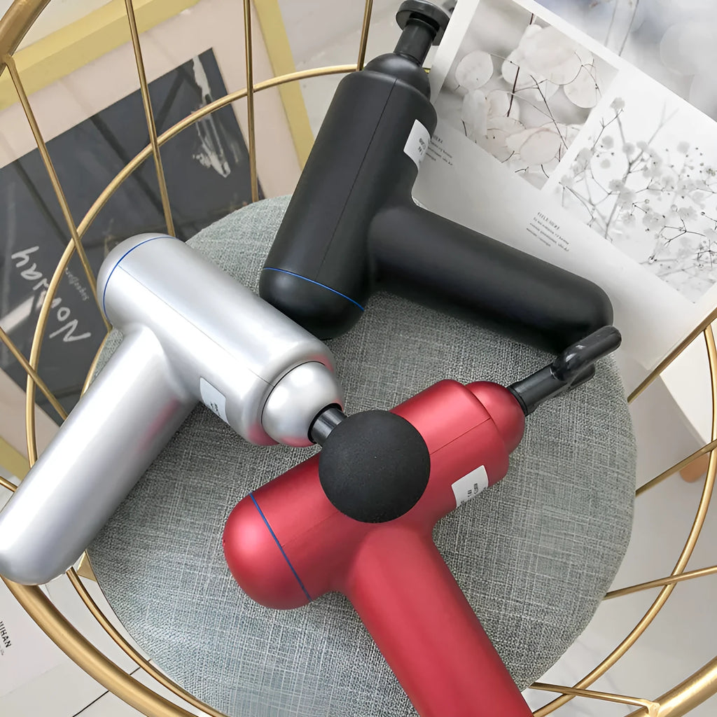 Grey handheld fascia gun massager on a plain background, showing ergonomic handle.
