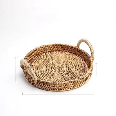 Round handwoven rattan storage basket with a light wooden handle on a table.