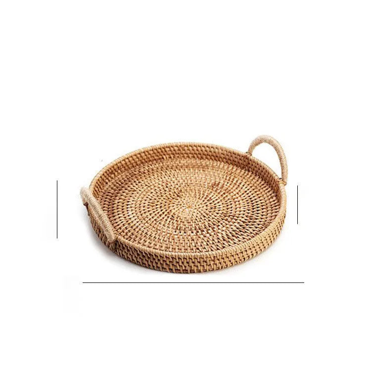 Round handwoven rattan storage basket with a light wooden handle on a table.