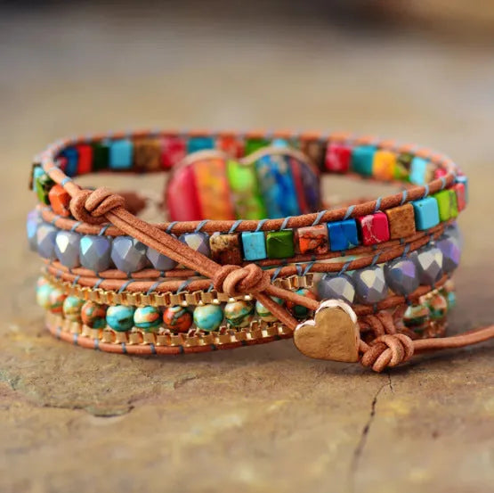 7 chakra leather wrapped bracelet with royal jasper crystal and agate beads on a flat surface