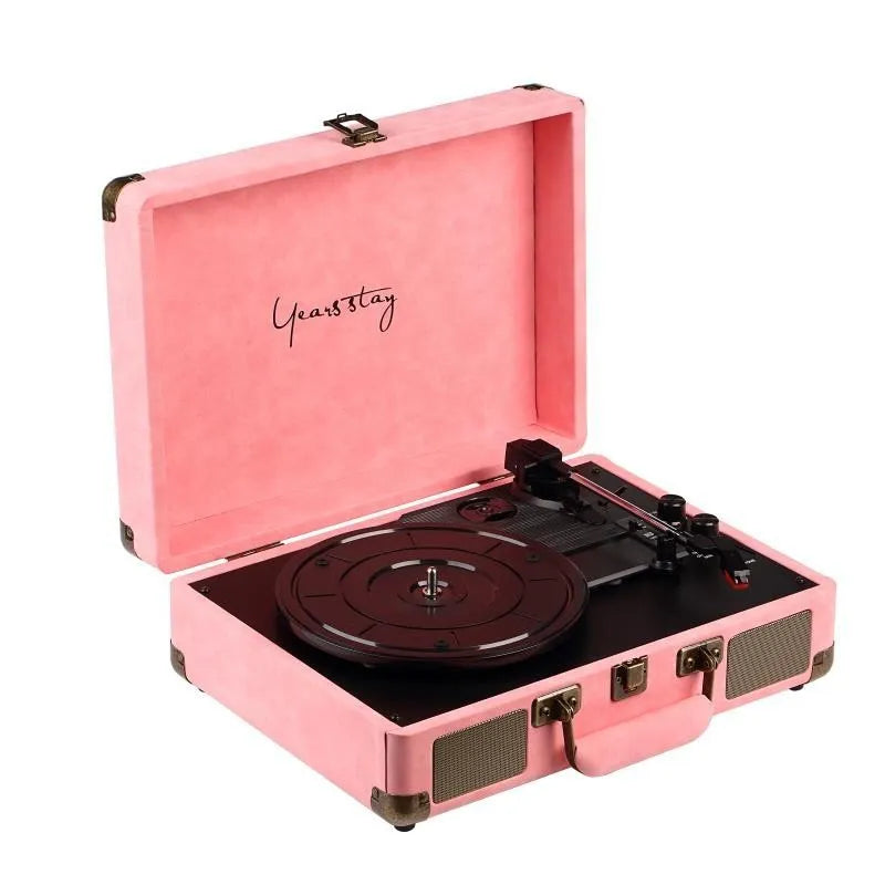 A black leather case Bluetooth turntable for vinyl and film records on a wooden surface.