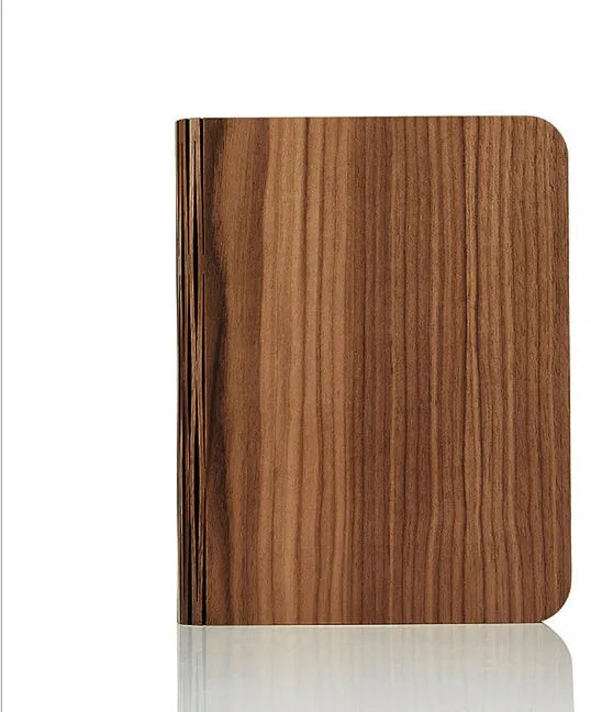 Solid wood USB-powered book light in three sizes on a desk with a book.
