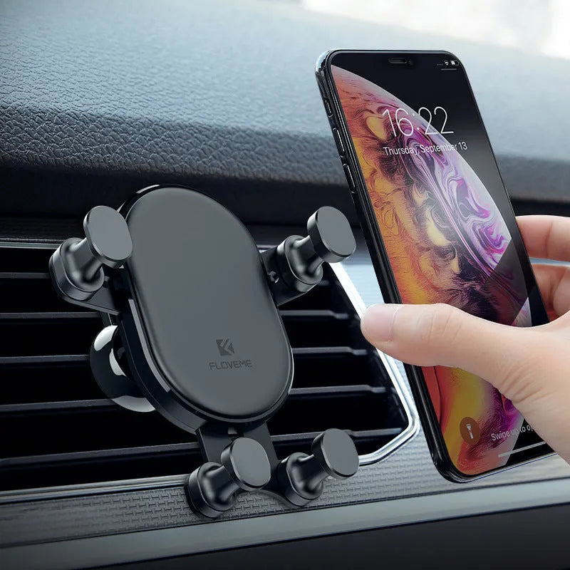 Black gravity car phone holder mounted on a car air vent, showing 360-degree rotation mechanism