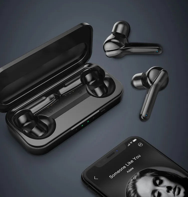 Black and white true wireless stereo earbuds with a compact charging case on a table.