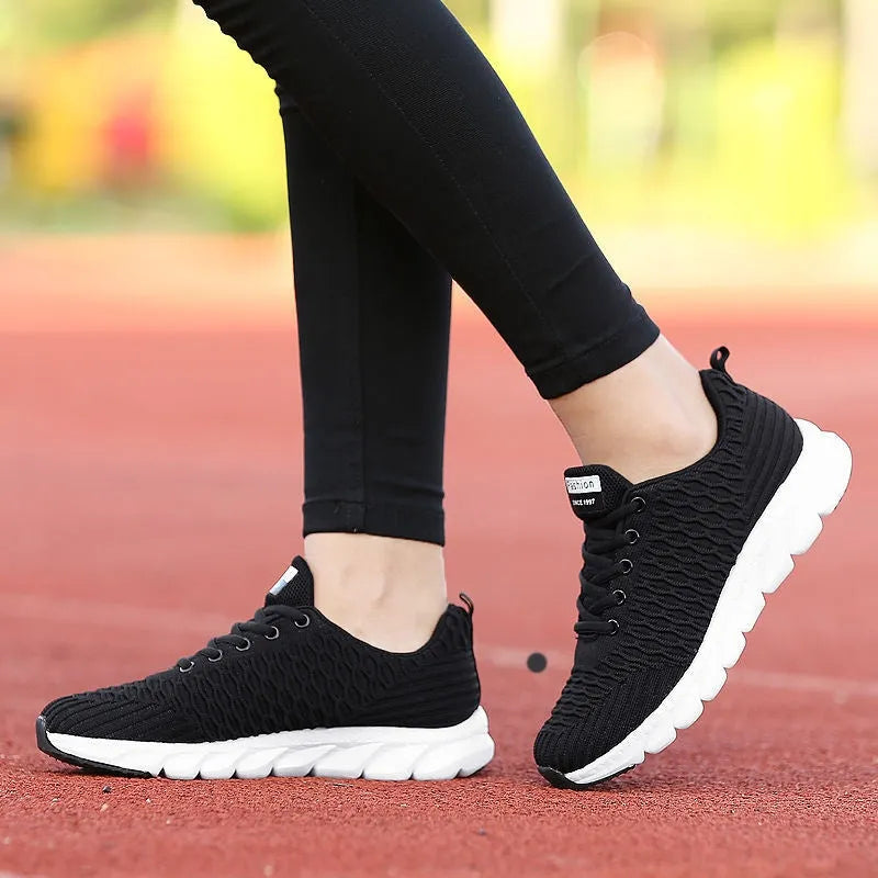Women's black running shoes with fly weaving upper and wear-resistant outsole.
