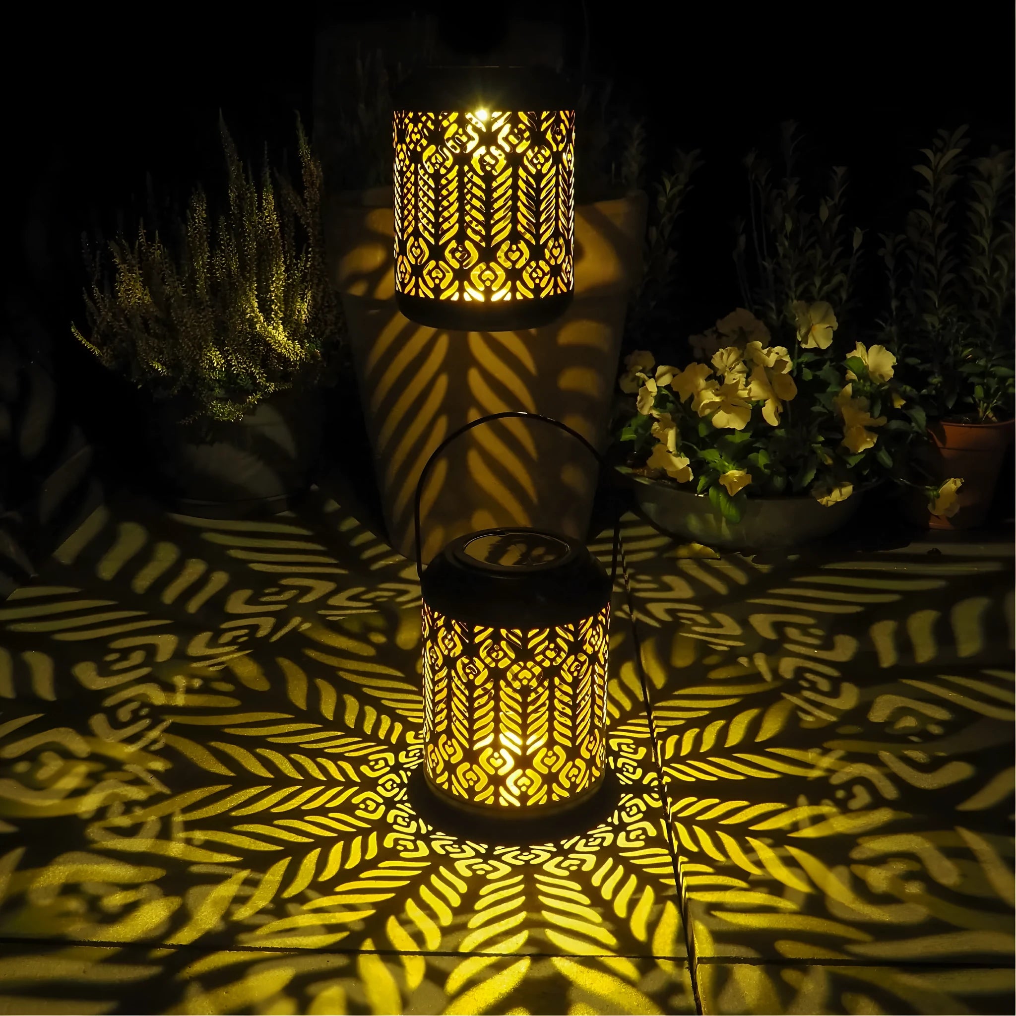 Black iron circular solar lamp with small cylindrical wheat ear design on a garden path