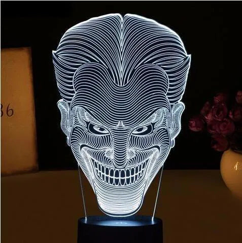 A 3D acrylic LED desk lamp showing multicolour gradient lighting, sitting on its square base with a USB cable.