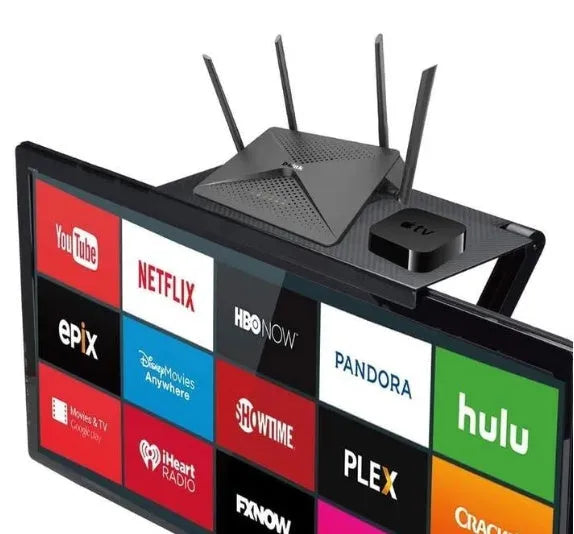 Black adjustable screen top shelf on a desktop monitor holding a streaming device and remote