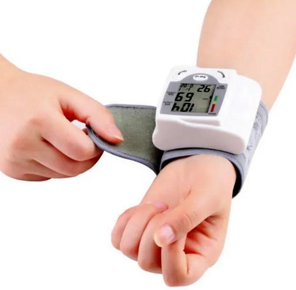 Grey portable wrist blood pressure monitor with digital display showing measurements