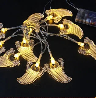 Halloween LED string lights with pumpkin, bat, and ghost decorations hanging on a wall