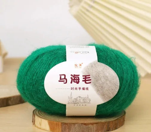 A ball of mohair thread in a chosen colour next to a hand-woven textured scarf sample.