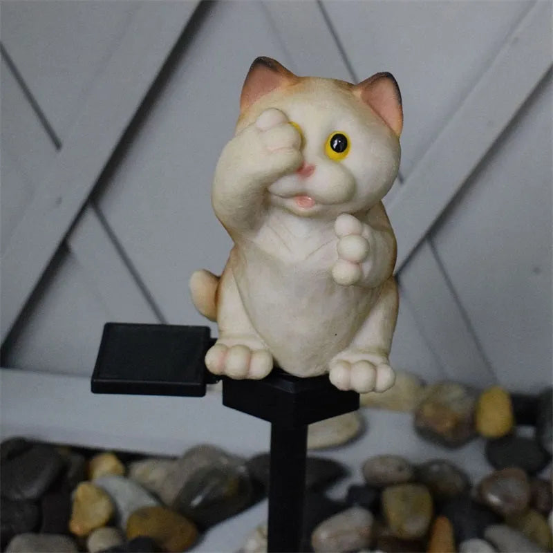 Brown cat-shaped solar lawn light with LED, placed in a garden.