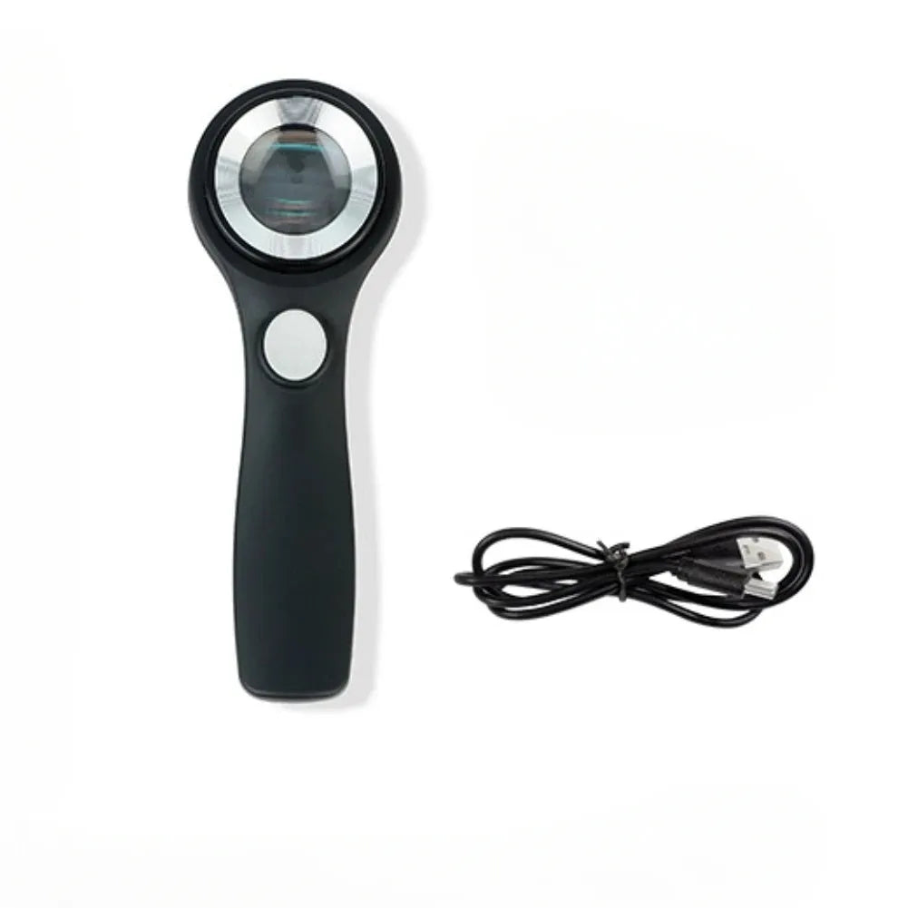 Illuminated black magnifying glass with optical glass lens for jewellery and stamp appraisal on a table.