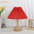 Vintage pleated umbrella-shaped USB bedside lamp with remote control on a wooden table.