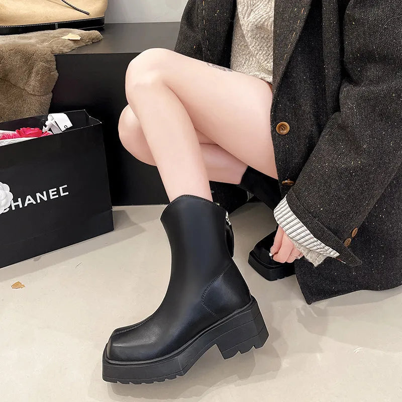 Women's black platform Martin boots with a square toe, chunky sole, and rear zip fastener