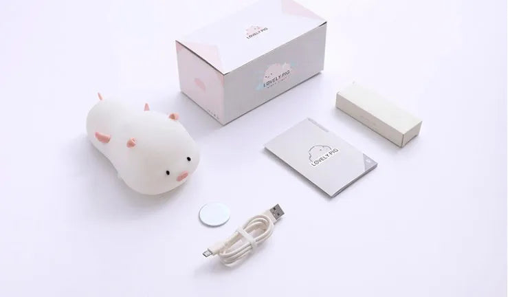 Blue or pink pig silicone night light with sleeping design, shown with dimensions and rechargeable battery.