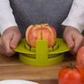 Green fruit slicer with three cutting sections for apple, tomato, and mango on a base