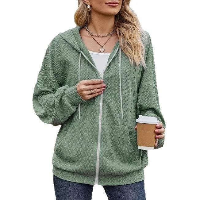Green women's loose hooded zip-up coat on a hanger, showing front zipper and long sleeves.