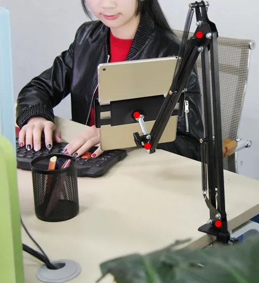 A black adjustable stand holding a mobile phone on a table.