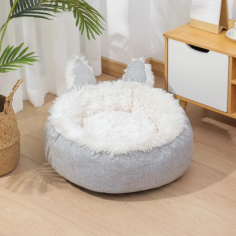Round plush faux fur cat bed with raised sides in blue colour showing soft texture