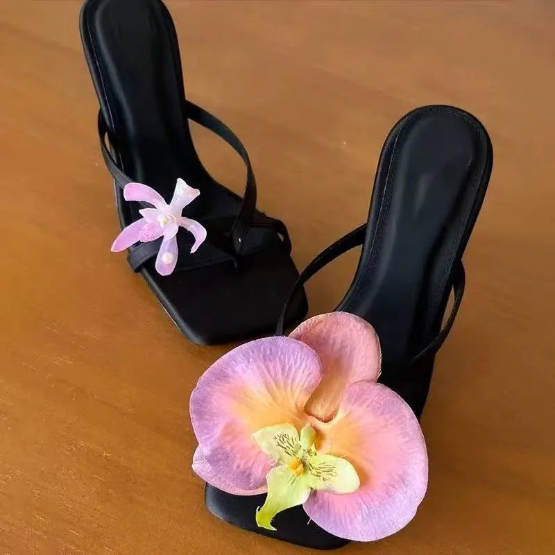 Women's handmade asymmetric flower high-heel sandals in black with a square toe and calf leather upper.