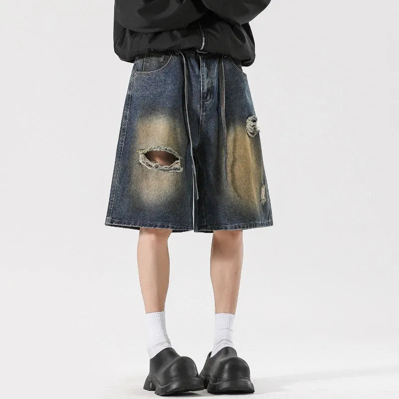 Loose-fit ripped jeans in retro blue denim, shown on a model, highlighting the baggy fit and distressed details.