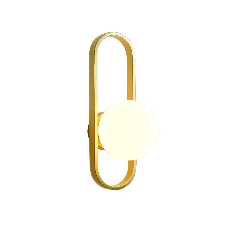 Modern minimalist wall lamp with black iron arm and clear glass shade, mounted on a plain wall.