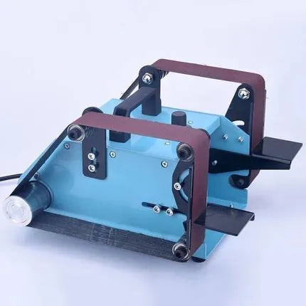 Blue desktop dual-axis belt sander with variable speed switch, shown on a workbench.