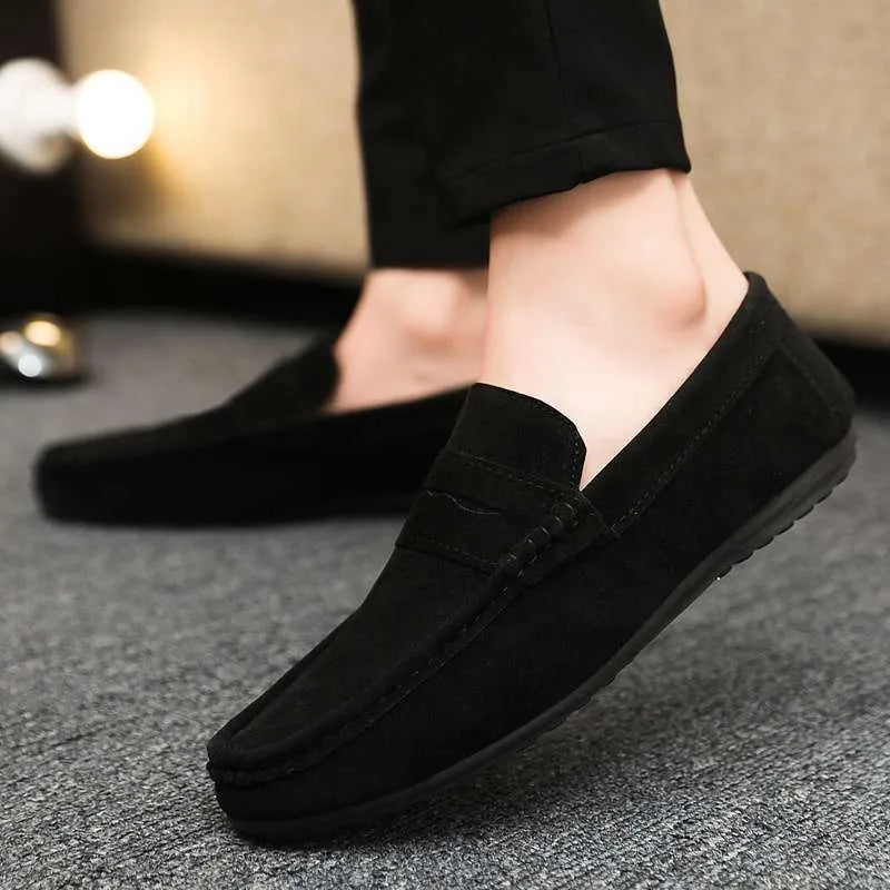 Men's black slip-on shoes with round toe, grape particle detail, and rubber sole.