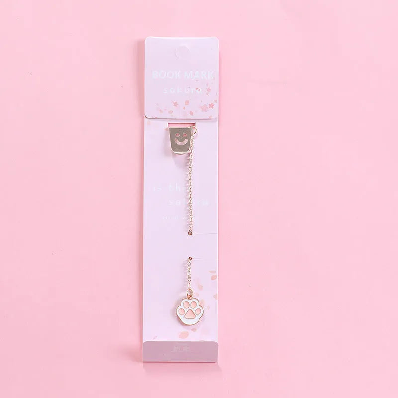 Cartoon-themed alloy metal bookmark charm on a book page.