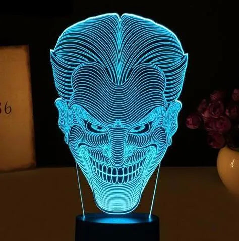 A 3D acrylic LED desk lamp showing multicolour gradient lighting, sitting on its square base with a USB cable.