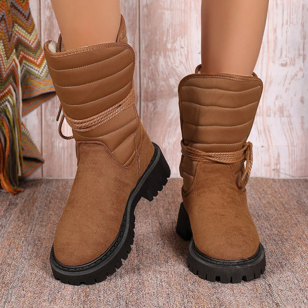 Women's black chunky heel snow boot with suede upper and lace-up design.