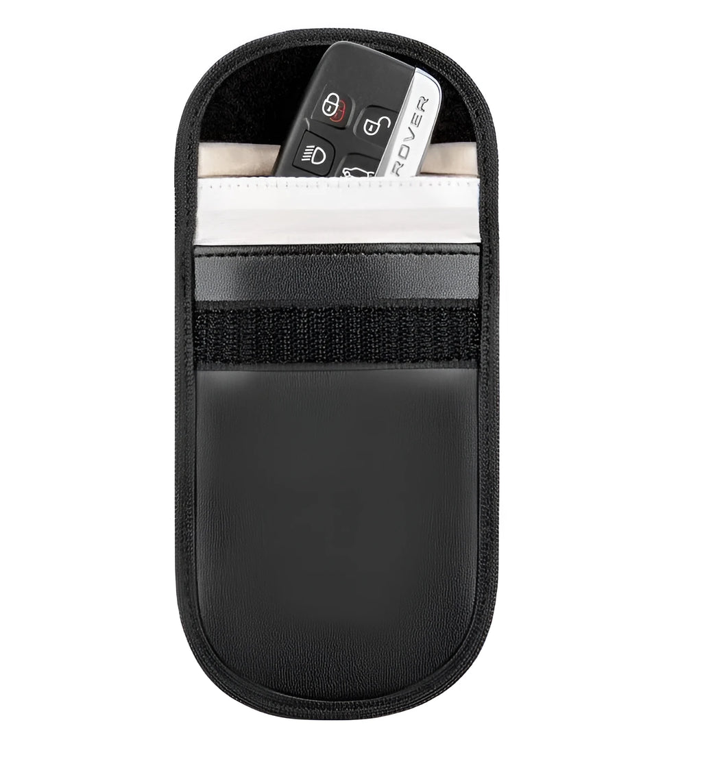 Black microfiber Faraday cage pouch for blocking car key and RFID card signals on a table.