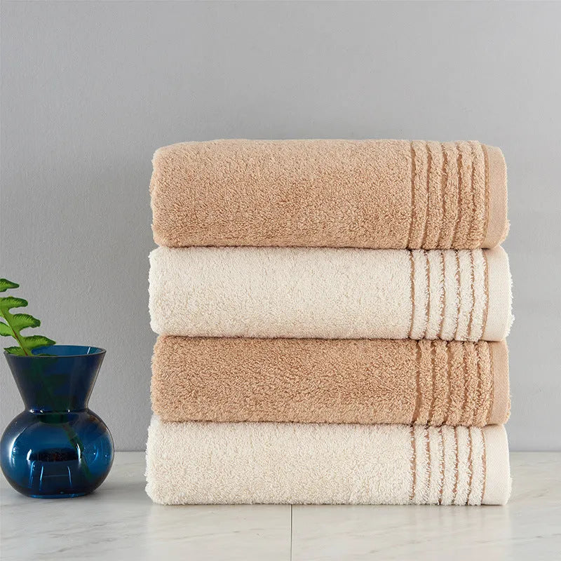 Cotton towel set in brown or beige showing bath sheet, hand towel, and face cloth sizes