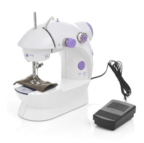 Small white plastic electric sewing machine with thread cutter and light on a table