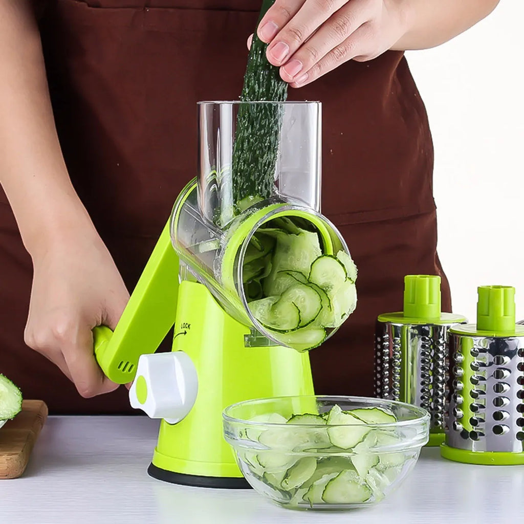 Blue green mandoline vegetable cutter with three stainless steel blades and rubber sucker base on kitchen counter