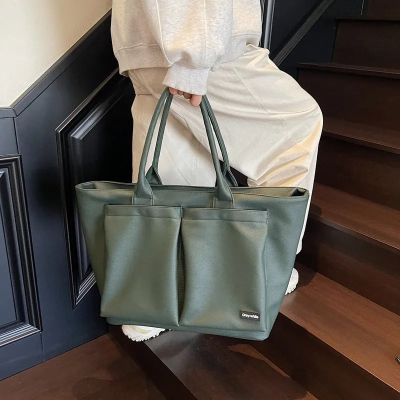 Lightweight expandable PU shoulder bag shown in solid green colour with ventilation panel