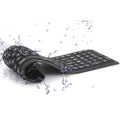 Black Bluetooth folding silicone keyboard with 108 keys and IP67 waterproof rating placed on a desk