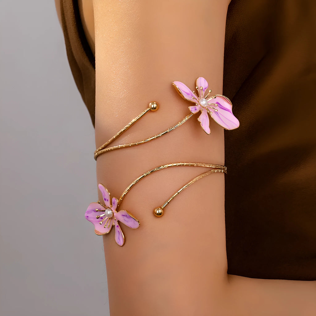 Close-up of a pink adjustable alloy armband with a hollow line pattern on a wrist.
