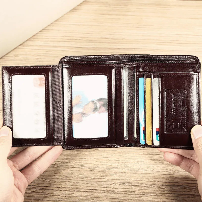 Men's black full-grain leather bifold wallet showing open interior with card slots and an exterior zippered coin pouch.