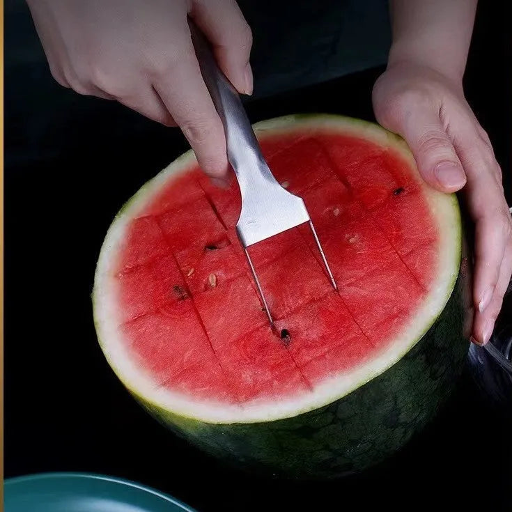 Stainless steel watermelon slicer and fork tool on a kitchen counter