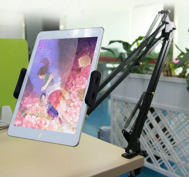 A black adjustable stand holding a mobile phone on a table.