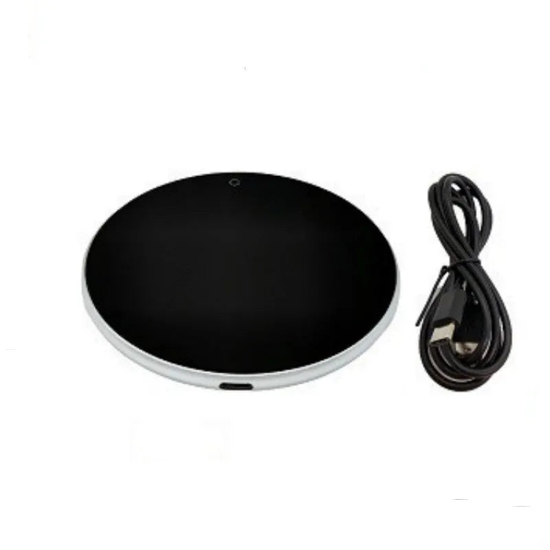 Black USB-powered beverage heating coaster with touch control and coloured LED lights on a wooden desk.