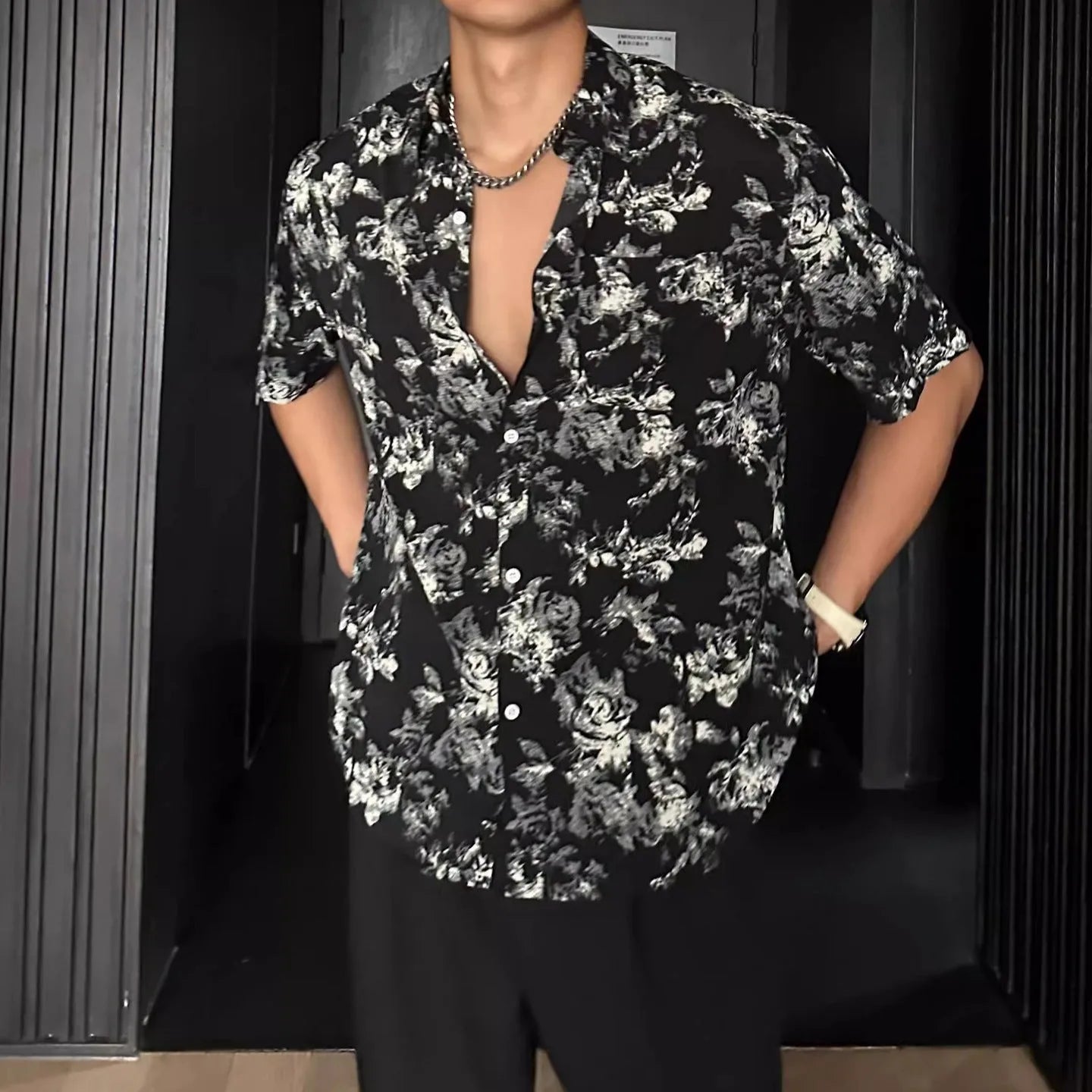 Loose fit floral printed short sleeve shirt in black, hanging on a hanger.